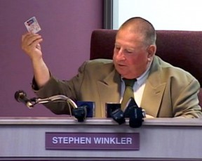 During a June 18 meeting, Winkler offers up a driver's license as evidence of his residency in the district.