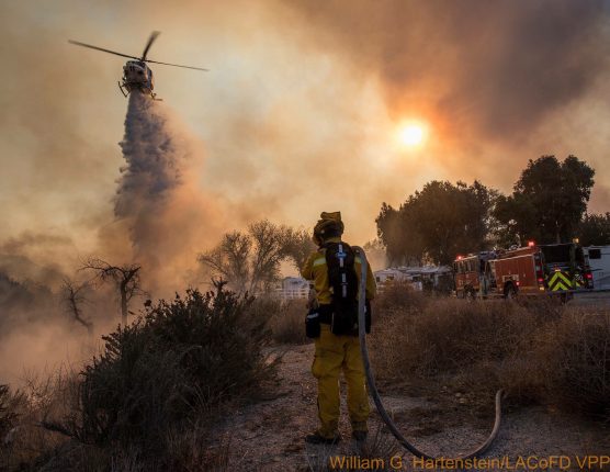 A firefighter watches a helicopter drop water on the Rye Fire on Dec. 5, 2017. | Photo: William G. Hartenstein, LA County Fire