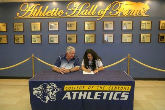 College of the Canyons head coach Greg Herrick looks on as sophomore guard Dayna Tanaka officially commits to continue her playing career at La Sierra University, a four-year program located in Riverside.