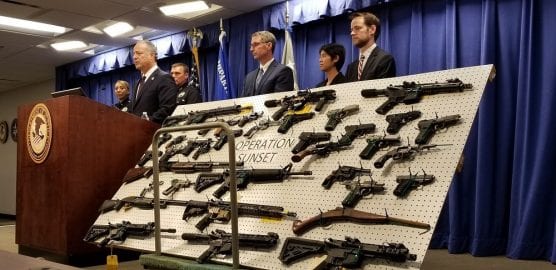 United States Attorney Nicola Hanna details the indictments of two violent Los Angeles street gangs before a wall of seized firearms on Feb. 13, 2019. (Nathan Solis/CNS)