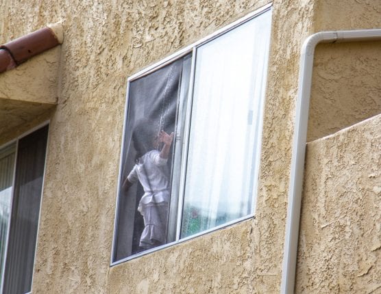 Santa Clarita Valley Sheriff’s Station deputies work to keep a child from falling through a window screen on the second floor of an apartment building in Canyon County Wednesday. | Photo: Austin Dave/The Signal.
