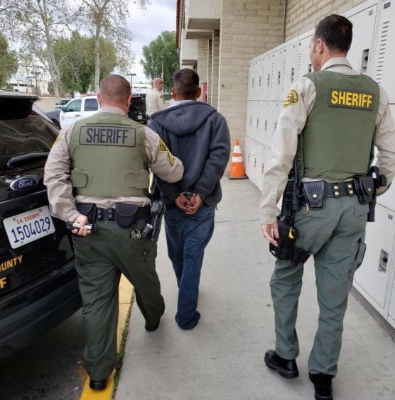 Crime Prevention Unit deputies lead David Cordova of Canyon Country to the booking desk at the Santa Clarita Valley Sheriff's Station on April 4, 2019. | LASD photo.