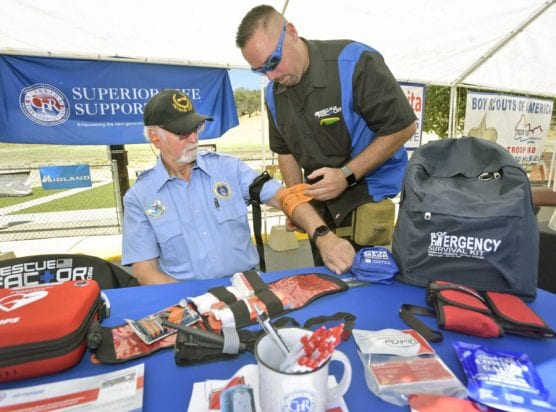 Patrick Emmerson, right, demonstrates how to apply two types of tourniquets on Jeff Stabile from a bleed control first aid kit at the Superior Life Support Inc. booth which was part of the Summer SAFE Fair held at Oak Tree Gun Club in Newhall on Saturday. | Photo: Dan Watson/The Signal.