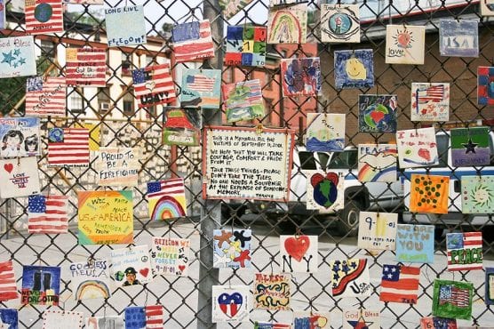 patriot day - A small monument to the victims of September 11, 2001, terrorist attacks is pictured on the fence of a car lot on Greenwich and Seventh Avenues in New York City. | Photo: DAVID ILIFF, license CC BY-SA 3.0.