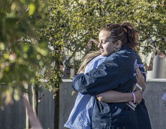 A guest wearing a "Saugus Strong" jacket embraces a fellow guest at the memorial service of Gracie Muehlberger Saturday afternoon, November 23, 2019. | Photo: Bobby Block / The Signal.