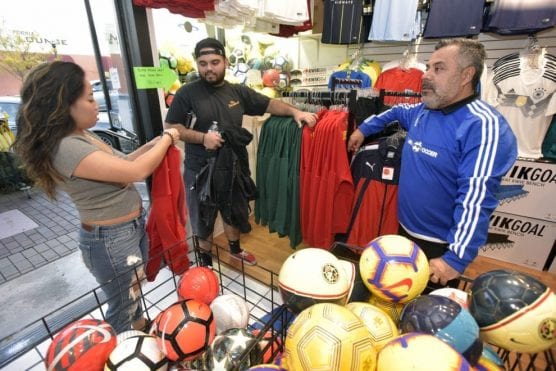 Planet Soccer owner Carlos Marroquin, right, helps shoppers Abby Buenafe, left, and Santiago Guzman as they pick out sweatshirts on Small Business Saturday at Planet Soccer in Newhall on Saturday, November 24, 2018. | Photo: Dan Watson / The Signal.