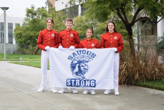 The Saugus band members selected for the Tournament of Roses Honor Band stand behind a #SaugusStrong banner. From left: Jason Treanor, Benjamin Bartel, Rachel Ramirez, Hannah Biane. Courtesy photo.