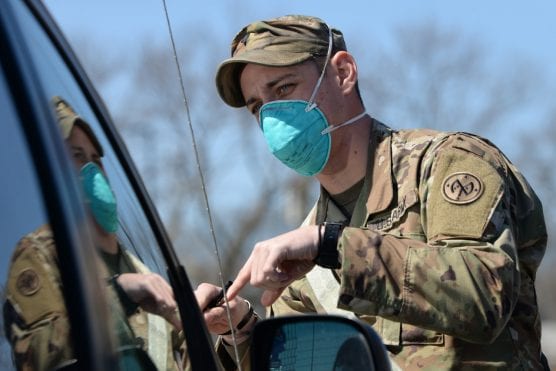 Army Spc. Montana Naccarato of Mount Gretna, Pa., assigned to the New York Army National Guard’s 69th Infantry Regiment, checks a motorist’s identification at a drive-through COVID-19 sampling site outside the Aqueduct Racetrack in Queens, N.Y., April 6, 2020. | Photo: Air Force Senior Airman Sean Madden, New York Air National Guard.